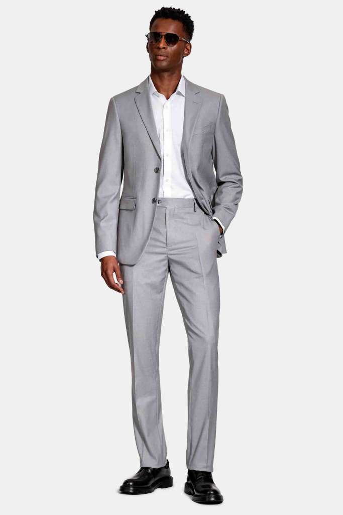 modelo masculino usando um terno cinza claro em um fundo branco 
