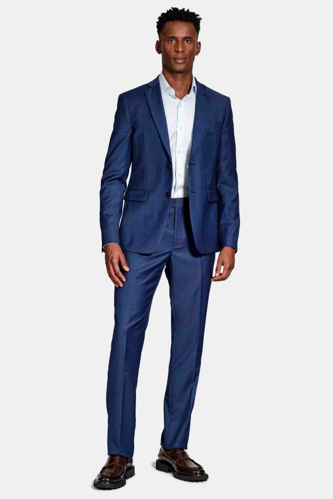 modelo masculino usando um terno azul marinho em um fundo branco 