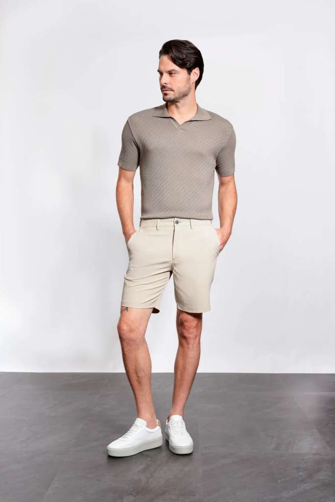 modelo masculino usando uma camisa polo e uma bermuda em um fundo branco 