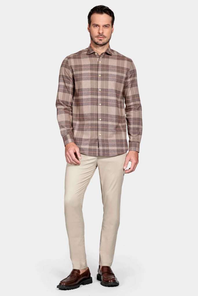 modelo masculino usando uma camisa xadrez e uma calça chino em um fundo branco 