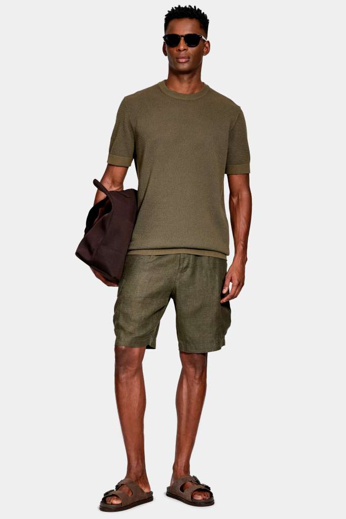 modelo masculino usando uma camisa tricot e uma bermuda em um fundo branco 